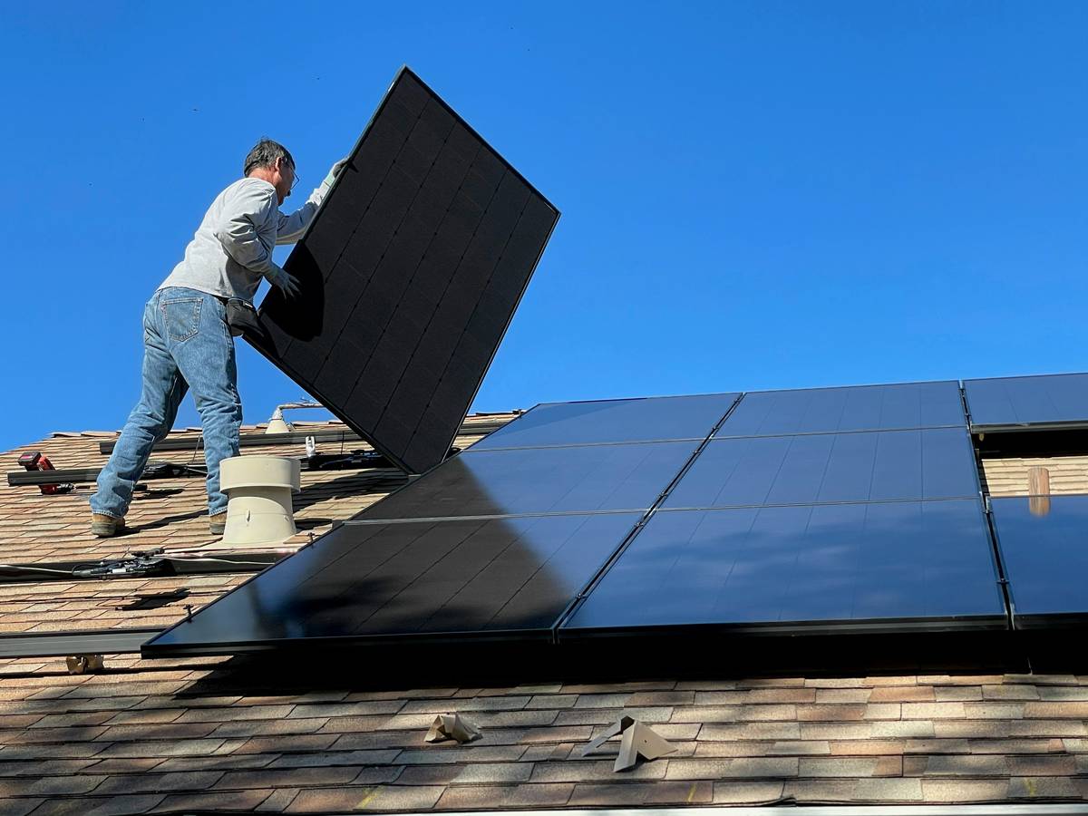 solar panel system benefits shown via labeled diagram of a rooftop installation with arrows pointing to energy flow, battery storage, and feed-in meter